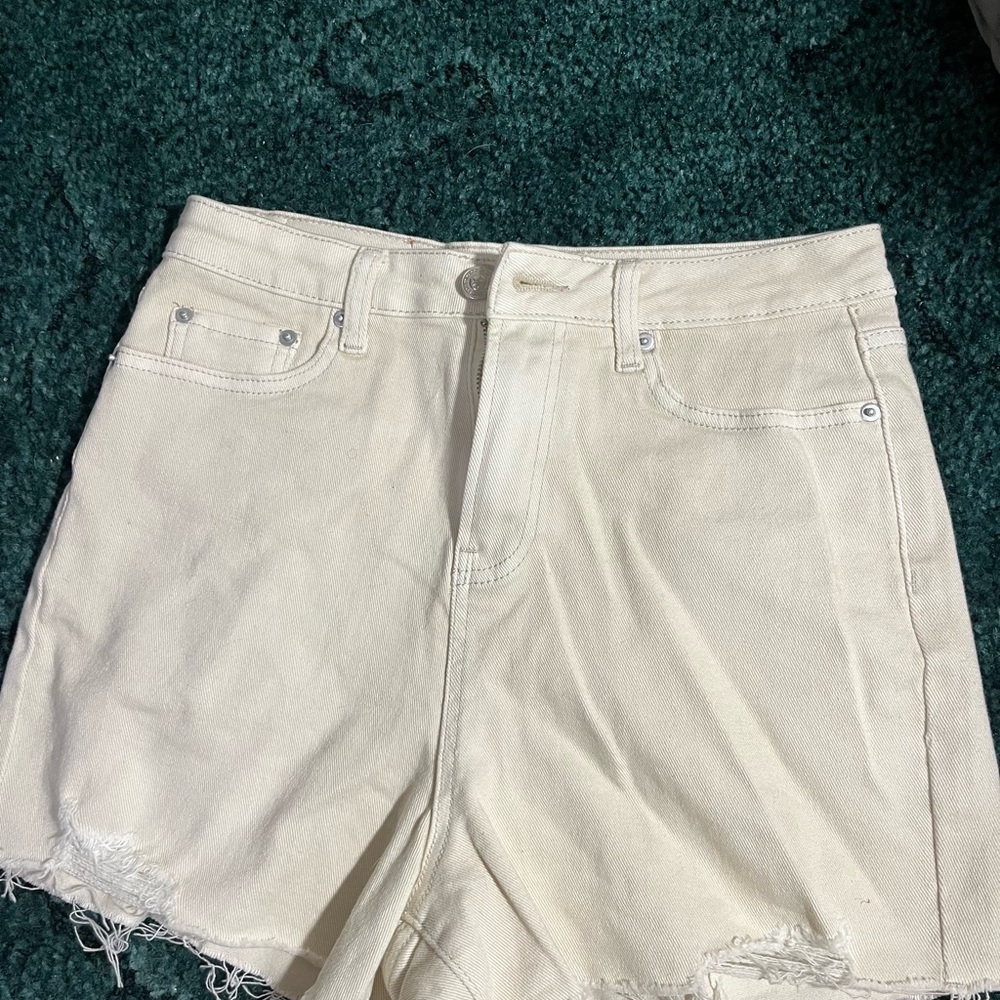 Cream colored denim shorts with tags